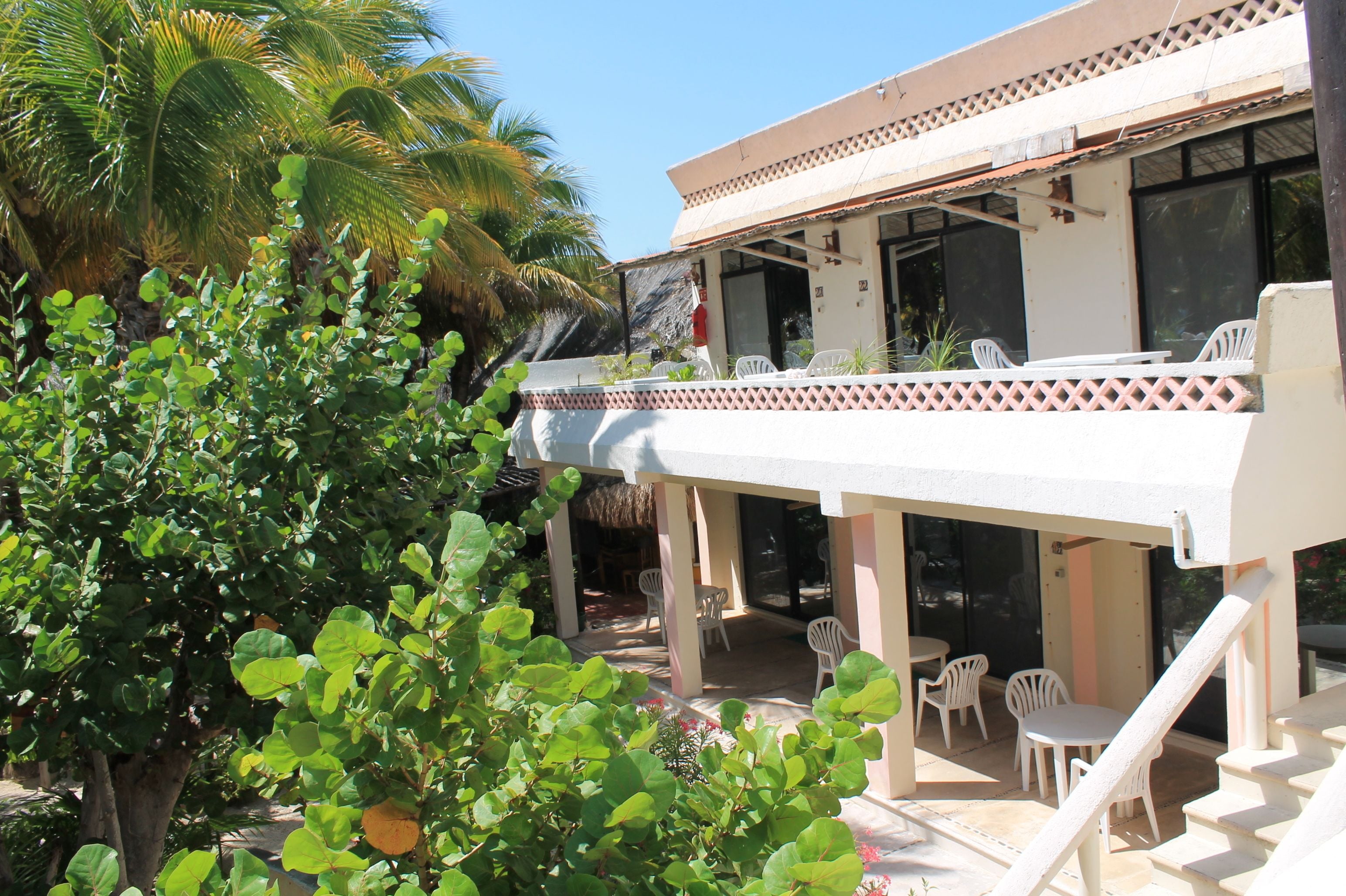 A two-story building with a covered patio area, outdoor seating, and a staircase leading to the upper floor.