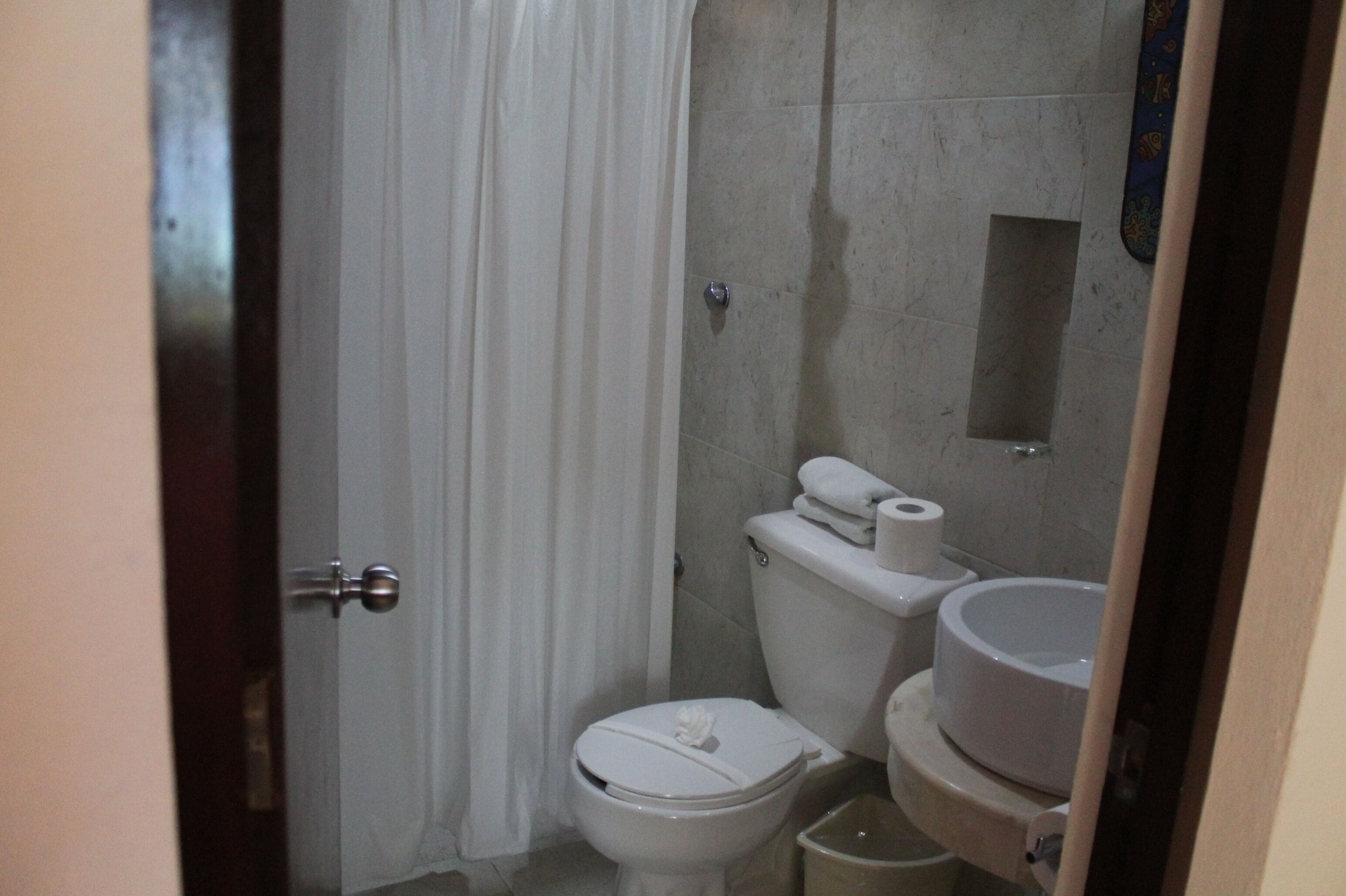 Une petite salle de bain compacte, équipée de toilettes, d’un bidet et d’un petit lavabo.