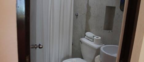 A small, compact bathroom with a toilet, bidet, and a small sink.