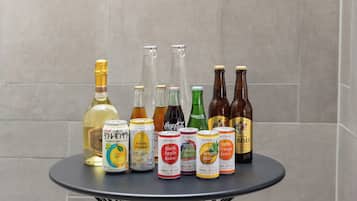A selection of beverages on a round table against a tiled wall.