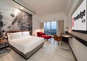 Relax in a spacious room with a large bed, city views, and a cozy seating area.