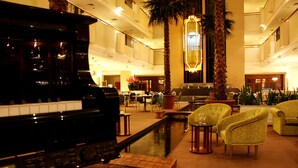 A grand piano in a spacious lobby with a pool, comfortable seating, and a high ceiling. - Travelodge Ipoh (Ipoh)