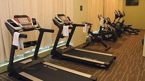 A hotel fitness room with multiple treadmills, each equipped with a digital display. - Travelodge Ipoh (Ipoh)