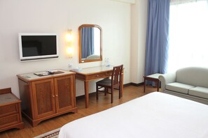 Relax in comfort with a large bed, desk, and flat-screen TV in this inviting space.