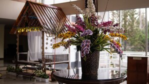 A room with a round table, a decorative birdhouse, and a window with a view of greenery. - Heritage Hotel Cameron Highlands (Tanah Rata)