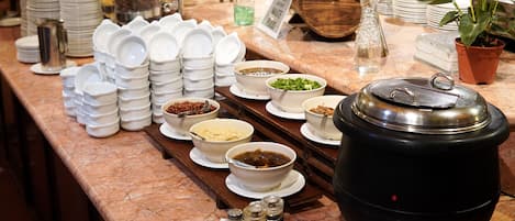 Una barra de buffet con diversos platos y acompañamientos.