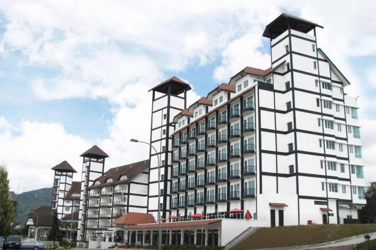 A multi-story hotel with a traditional European architectural style, featuring a prominent tower and a covered entrance area.
