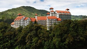 A large, multi-story building with a red roof, surrounded by dense forest and hills. - Heritage Hotel Cameron Highlands (Tanah Rata)