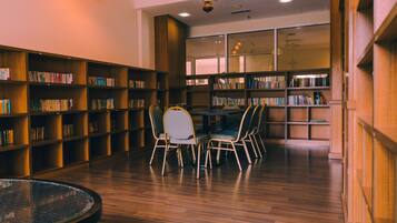 Una biblioteca con estanterías de madera, una mesa redonda y cuatro sillas.
