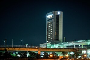 A modern building with a prominent tower, a covered walkway, and a bridge. - Kanku Izumiotsu Washington Hotel (Izumiotsu)