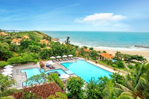 Una piscina al aire libre, sombrillas, tumbonas