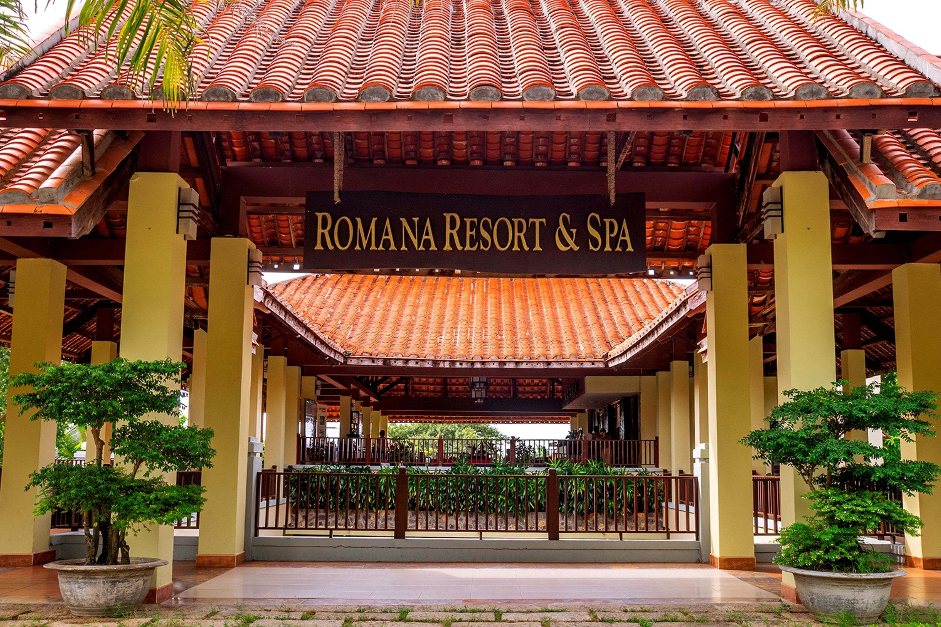 Un bâtiment traditionnel avec un toit en tuiles et une enseigne indiquant « ROMANA RESORT & SPA ».