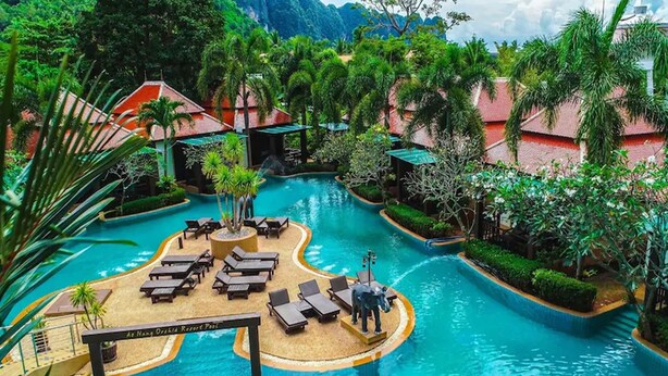 Een resort zwembad met ligbedden, palmbomen en een bord met de tekst 'As Ngan Orchid Resort Pool'.