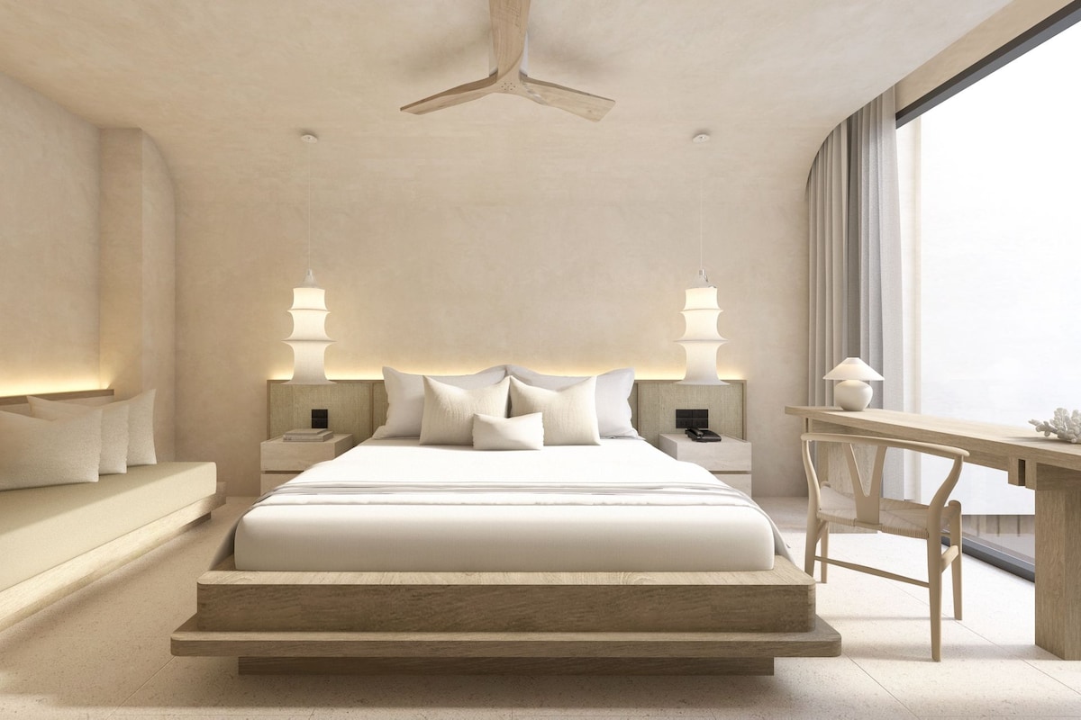 Une chambre d’hôtel moderne avec un grand lit, des tables de chevet, un bureau et une vue sur la ville.