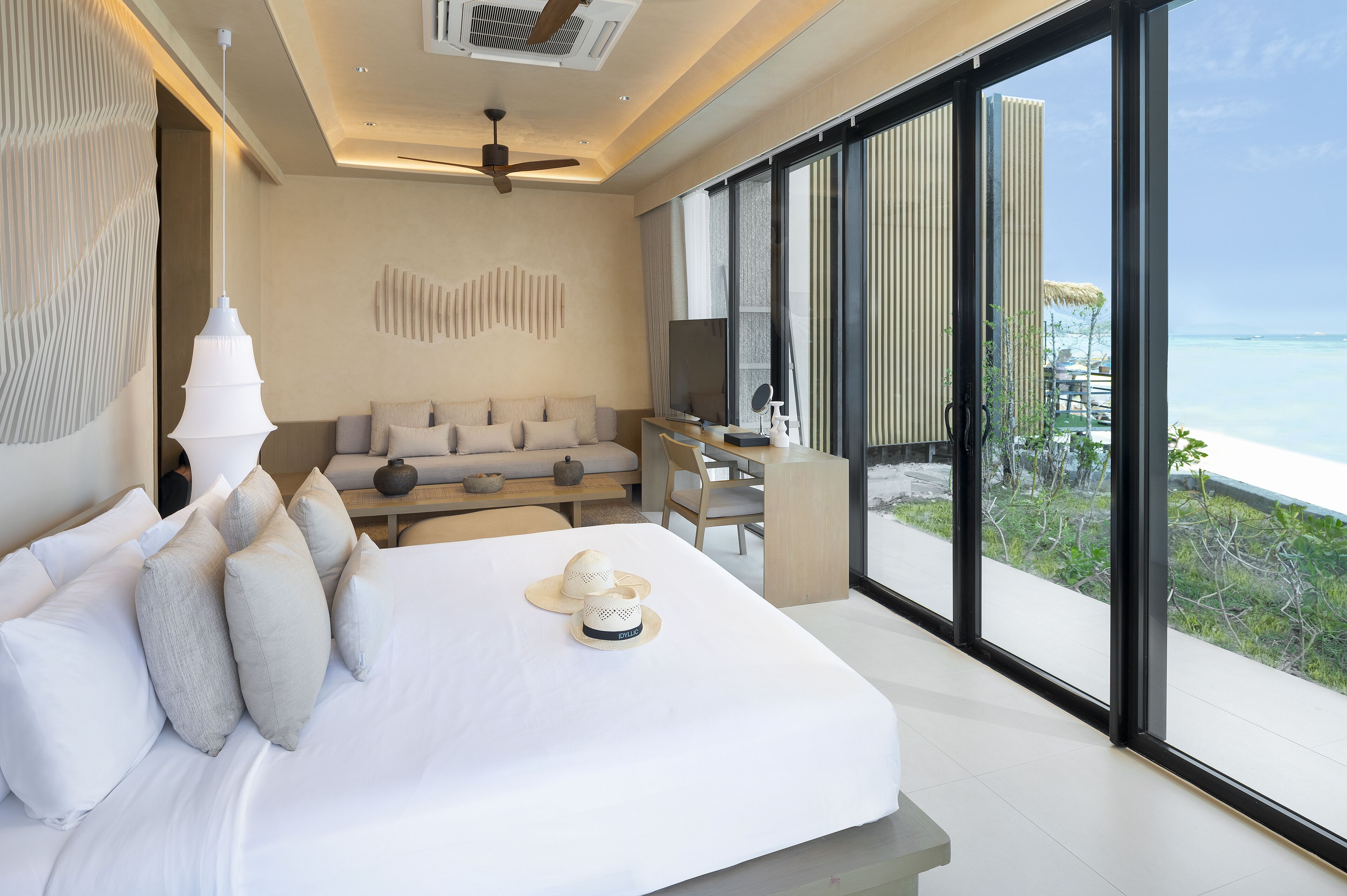 Camera d'albergo moderna con un letto grande, una scrivania, una televisione e vista sull'oceano.