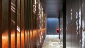A corridor with a patterned floor, metal railings, and a dark wall. - Hotel The Lodge Heverlee (Leuven)