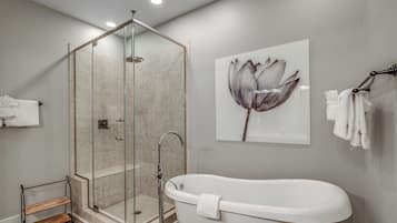 A modern bathroom with a glass-enclosed shower, a freestanding bathtub, and a wall-mounted towel rack.
