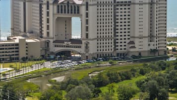 Un grand hôtel doté d’une arche centrale, de plusieurs étages et offrant une vue sur l’océan.