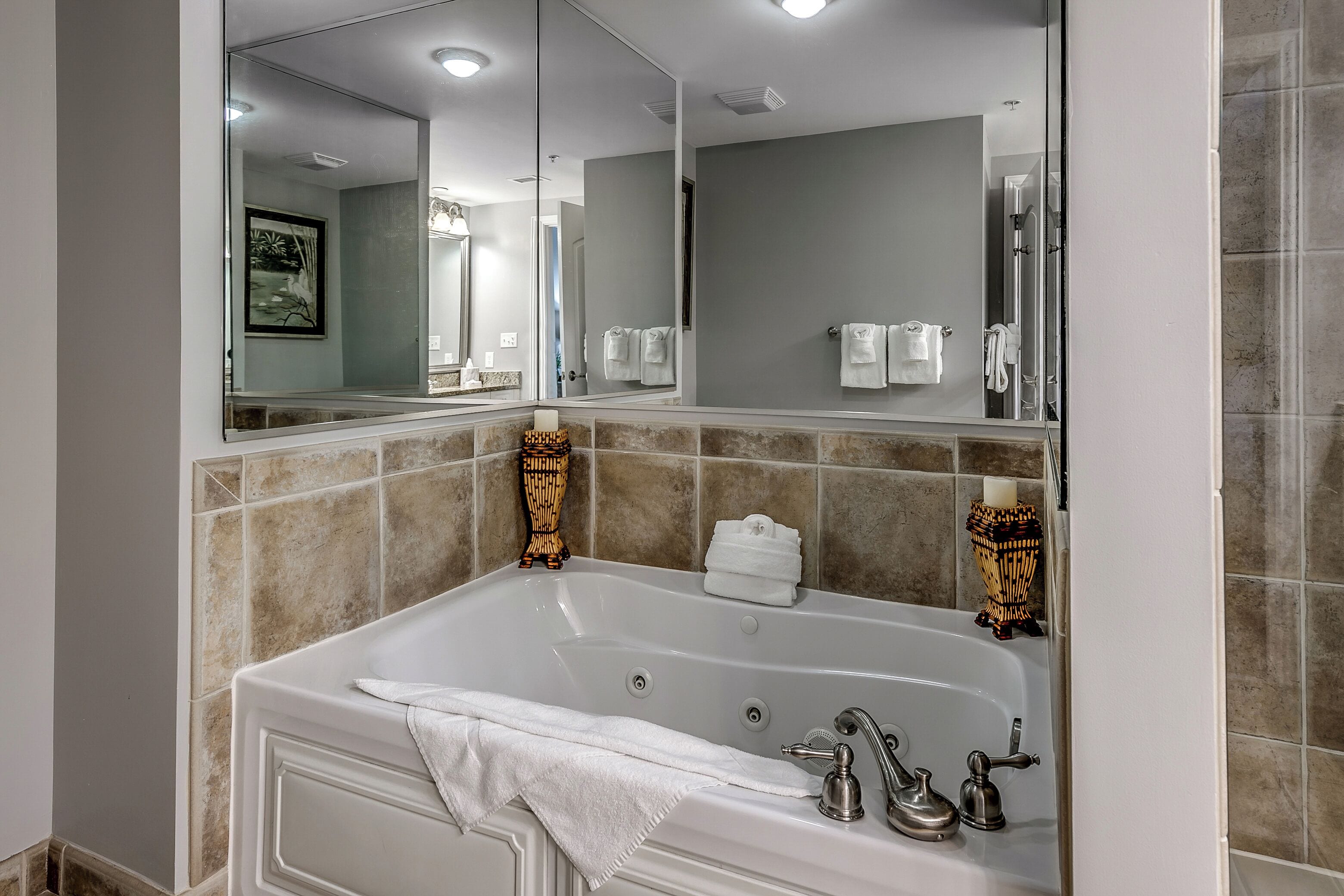 Un baño moderno con una bañera grande, un espejo amplio y un perchero para toallas.