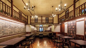 Una biblioteca amplia con mesas y bancos de madera, estanterías y un balcón con vistas.