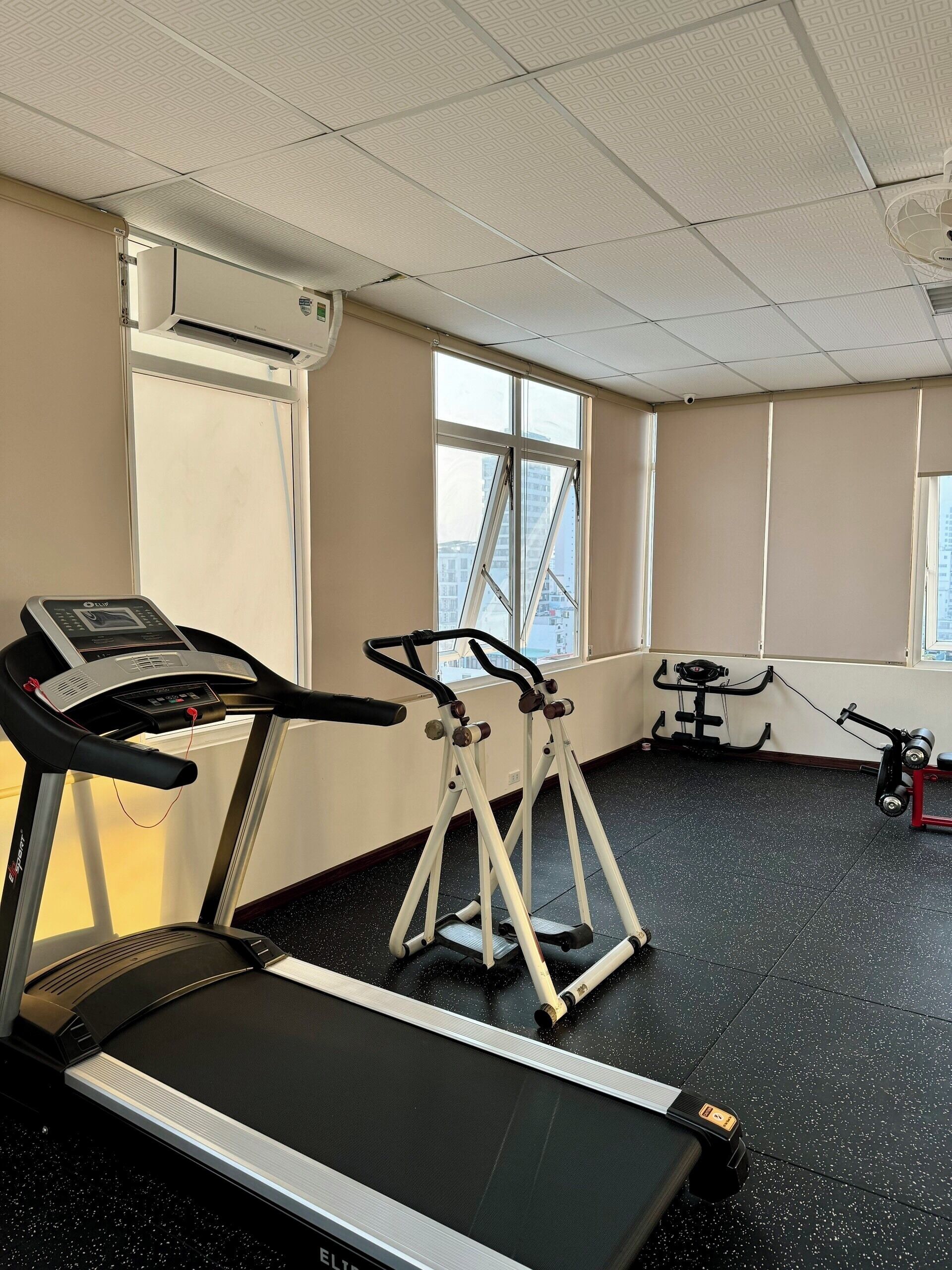 A gym with treadmills, ellipticals, and a stationary bike.