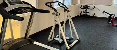 A gym with treadmills, ellipticals, and a stationary bike.