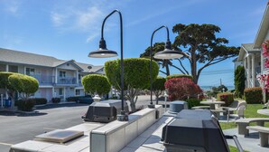 A residential street with houses, a barbecue area, and a clear view of the ocean. - Cayucos Beach Inn (Cayucos)
