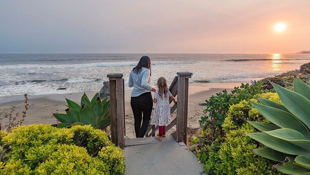 A pathway leading to a beach with a sunset in the background. - Cayucos Beach Inn (Cayucos)