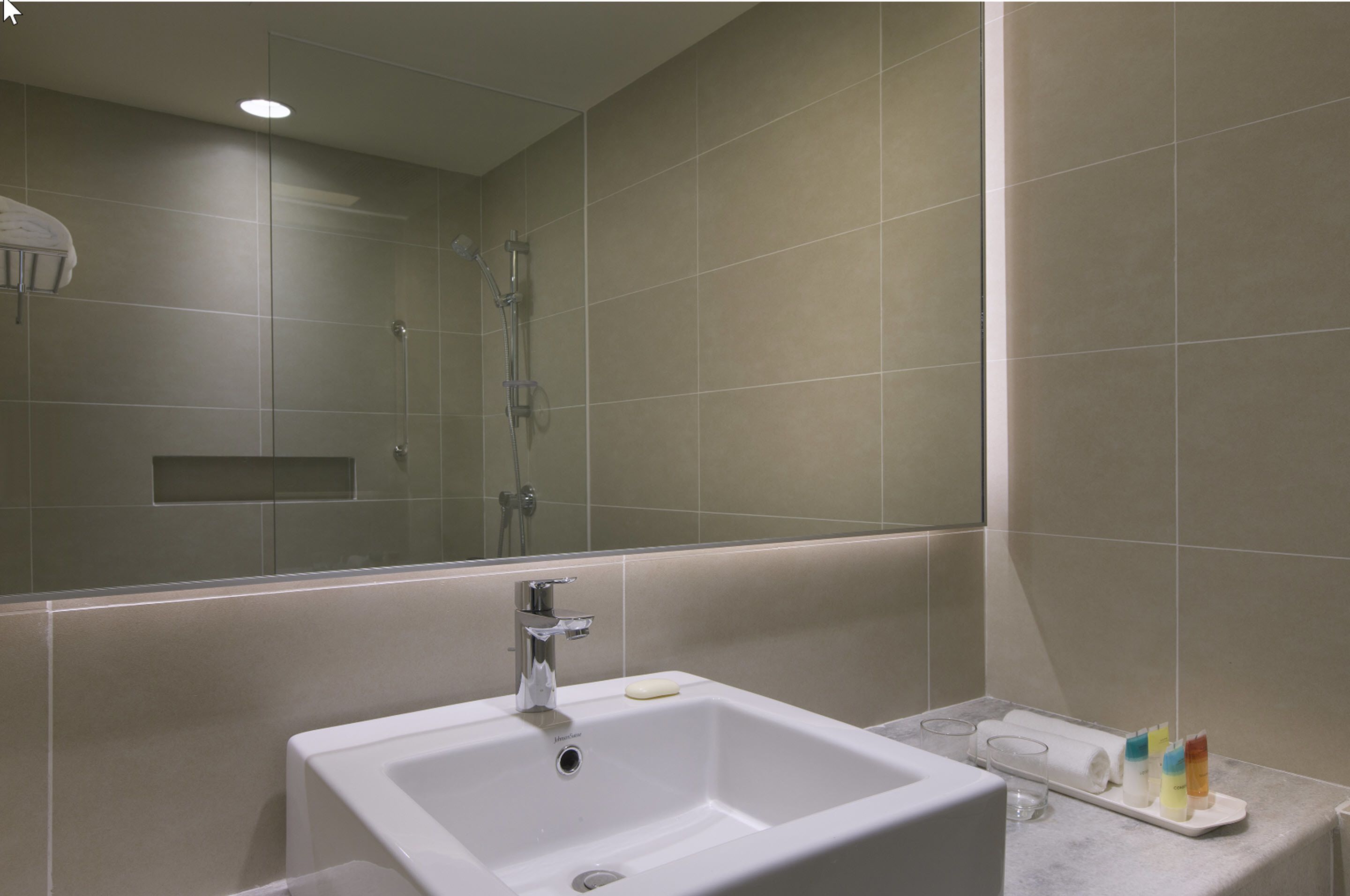 A bathroom with a white sink, a mirror, and a shower.