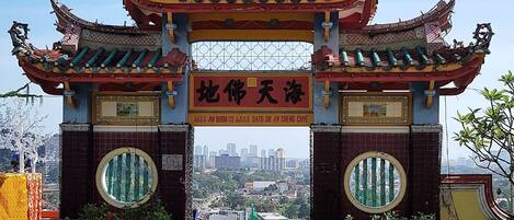 A traditional Chinese gate with ornate decorations and a clear view of the cityscape in the background.