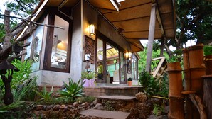 Un edificio de estilo tradicional con un camino de piedra que lleva a un porche de madera.