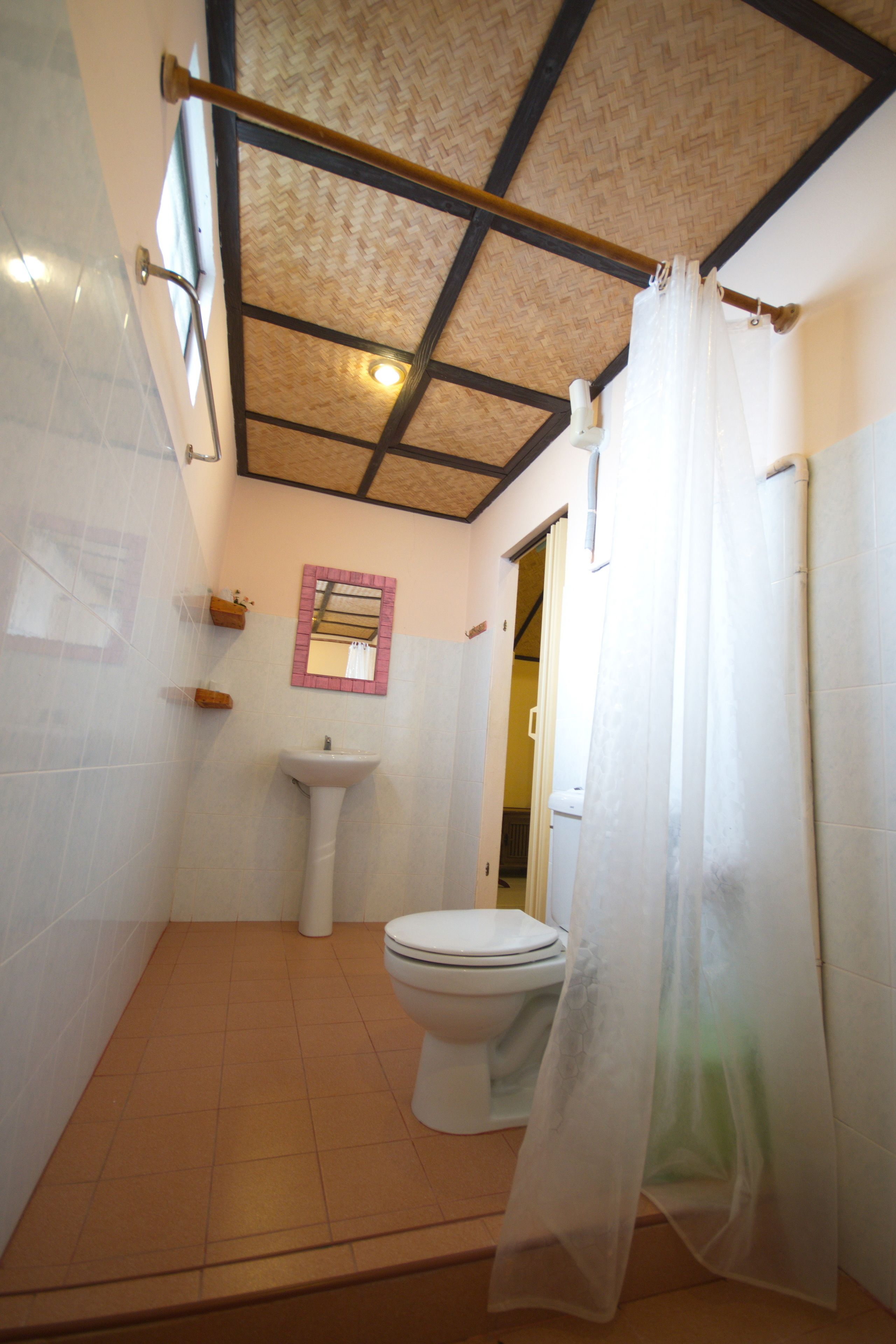 A bathroom with a toilet, sink, and shower curtain.