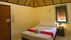 Un dormitorio con cama, puerta de madera, ventana con vistas y techo con diseño geométrico.