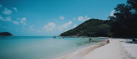 On the beach, white sand, beach umbrellas, beach towels
