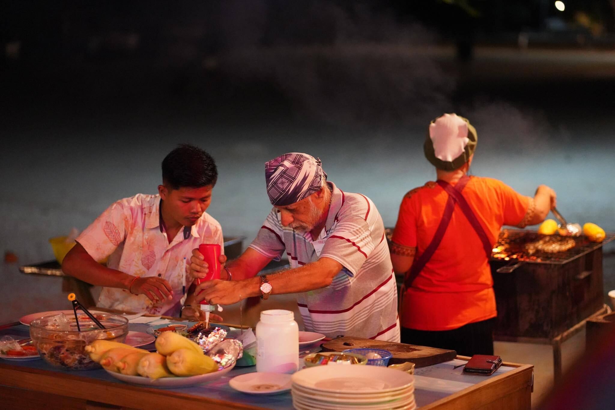 A group of people preparing food at a barbecue.