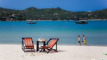 Aan het strand, wit zand, parasols, strandlakens