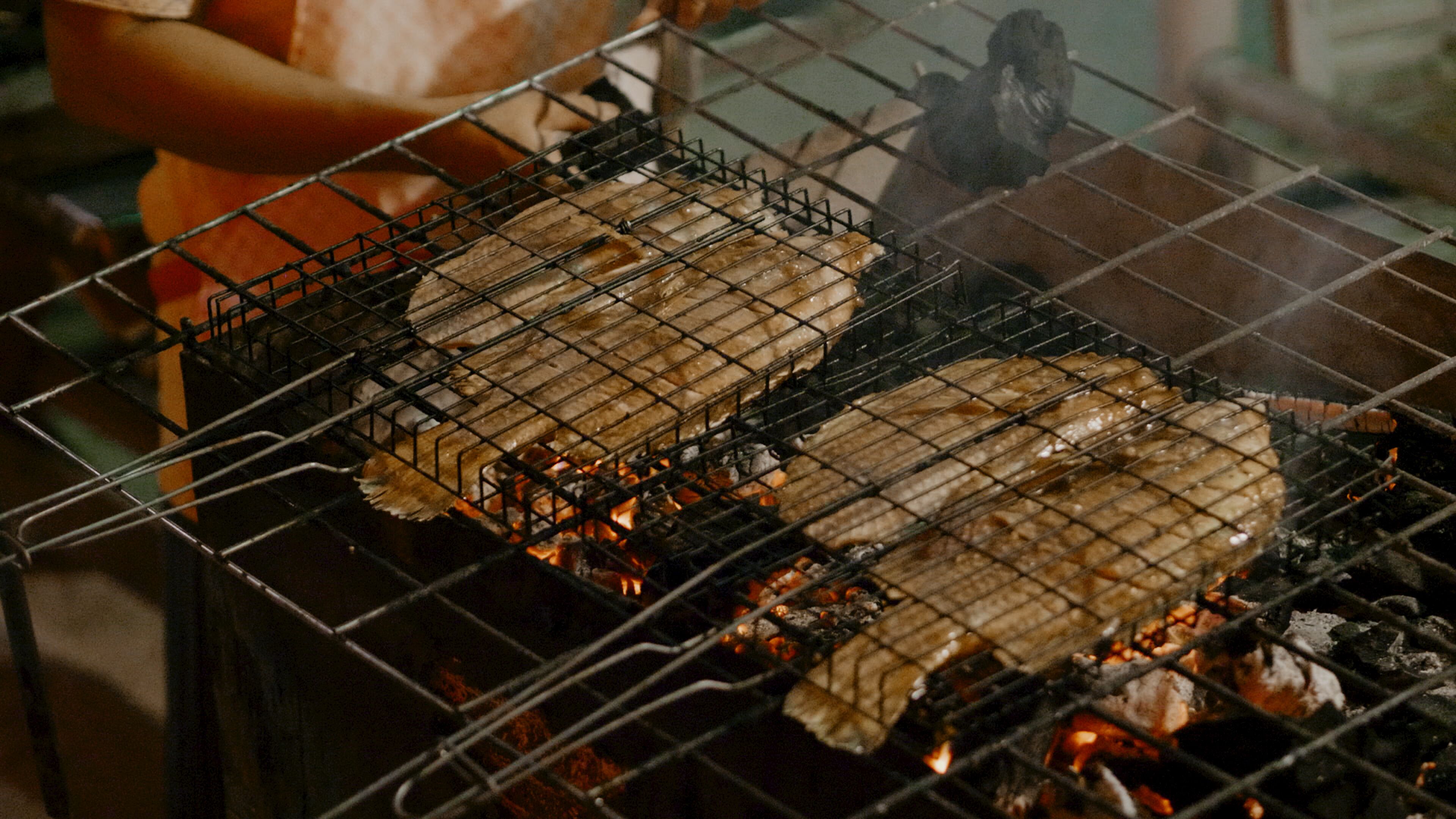 A grill with food being cooked over an open flame.