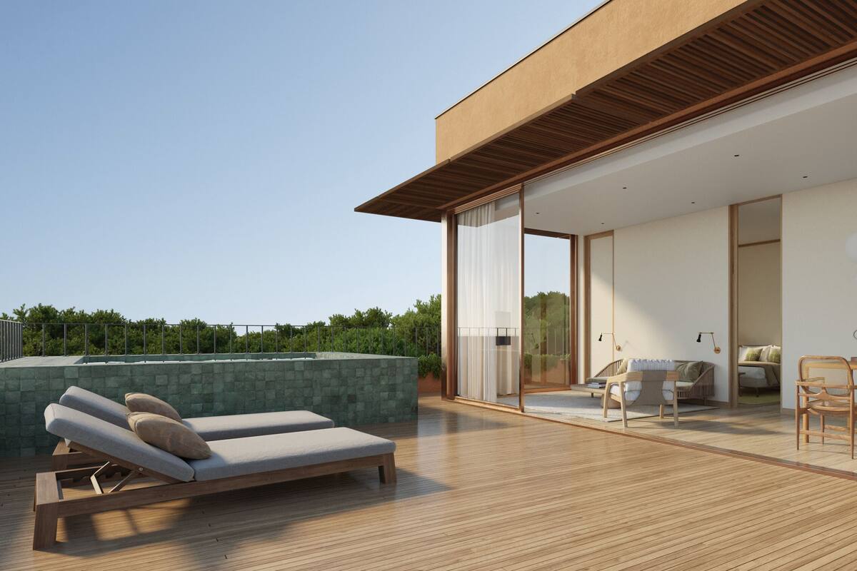 A modern house with a wooden deck, a glass door leading to a dining area, and a lounge chair.