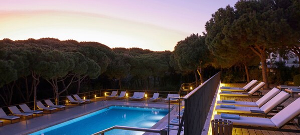 Una piscina al aire libre, tumbonas