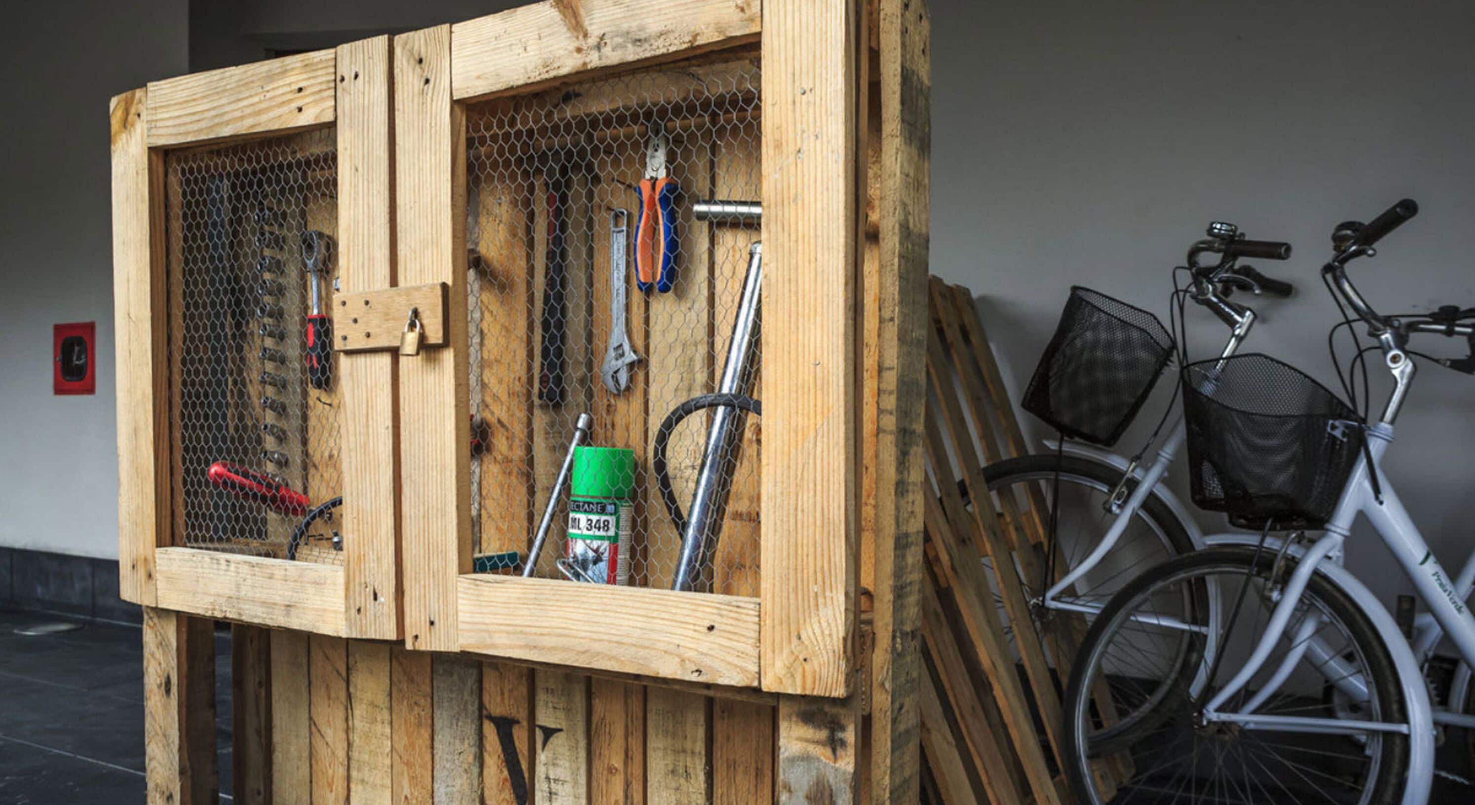 A wooden storage unit with tools and a bicycle.