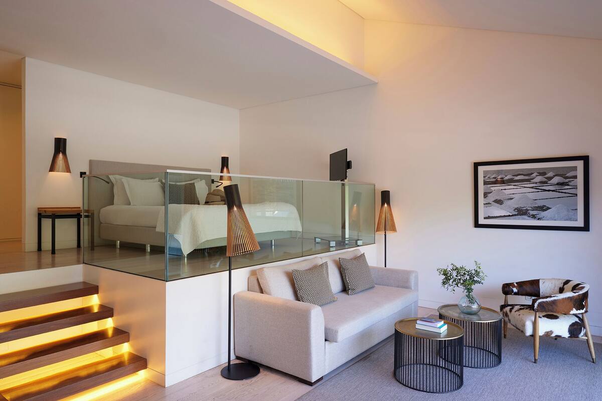 A modern living room with a glass partition, a sofa, a coffee table, and a chair.
