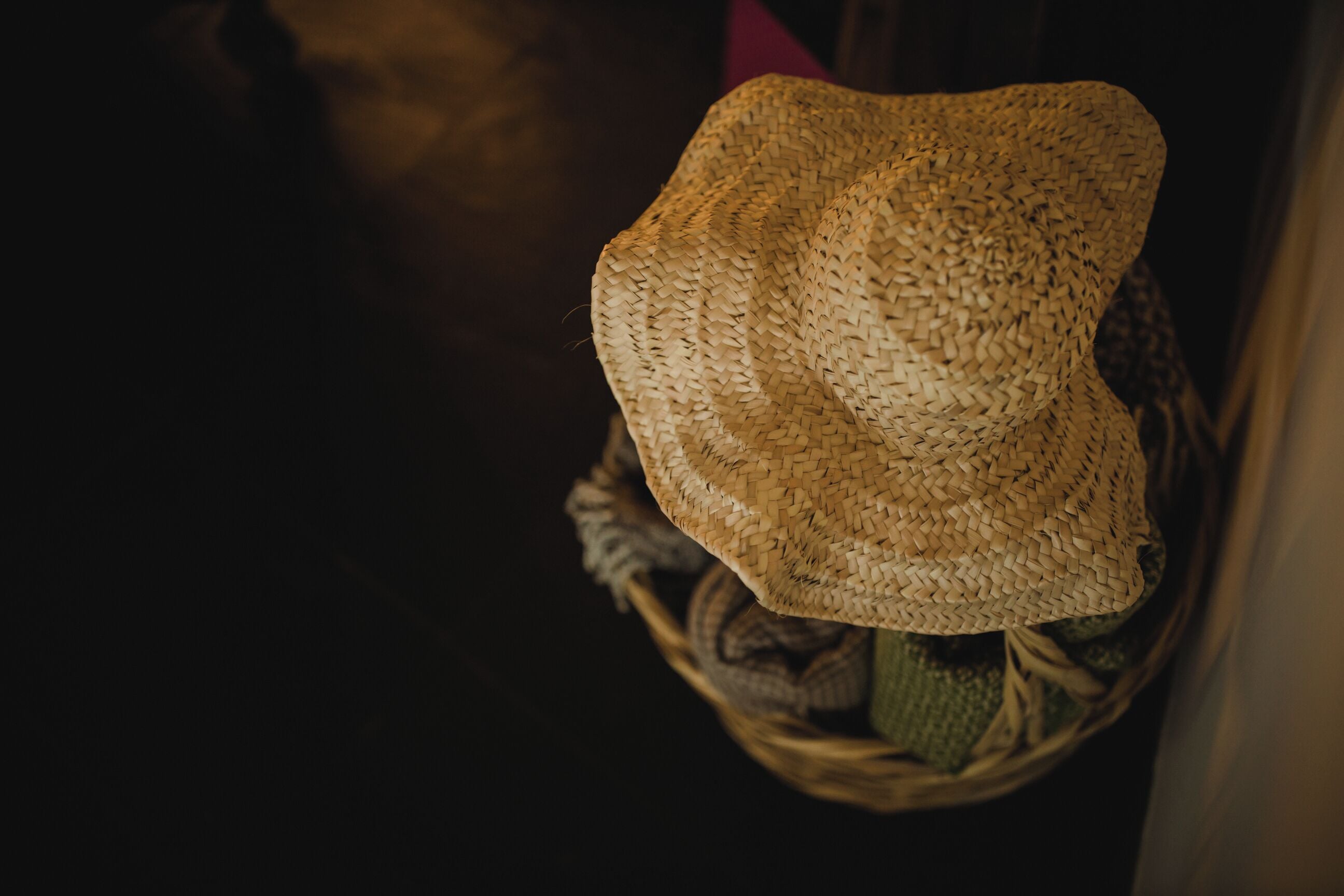 Un sombrero de paja sobre una cesta tejida.