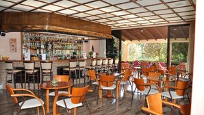 A bar area with wooden furniture and a variety of bottles. - Pegasus Hotel (Corfu)