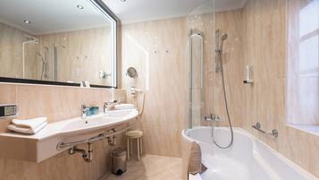 Ein modernes Badezimmer mit Badewanne, Dusche und Waschtisch.