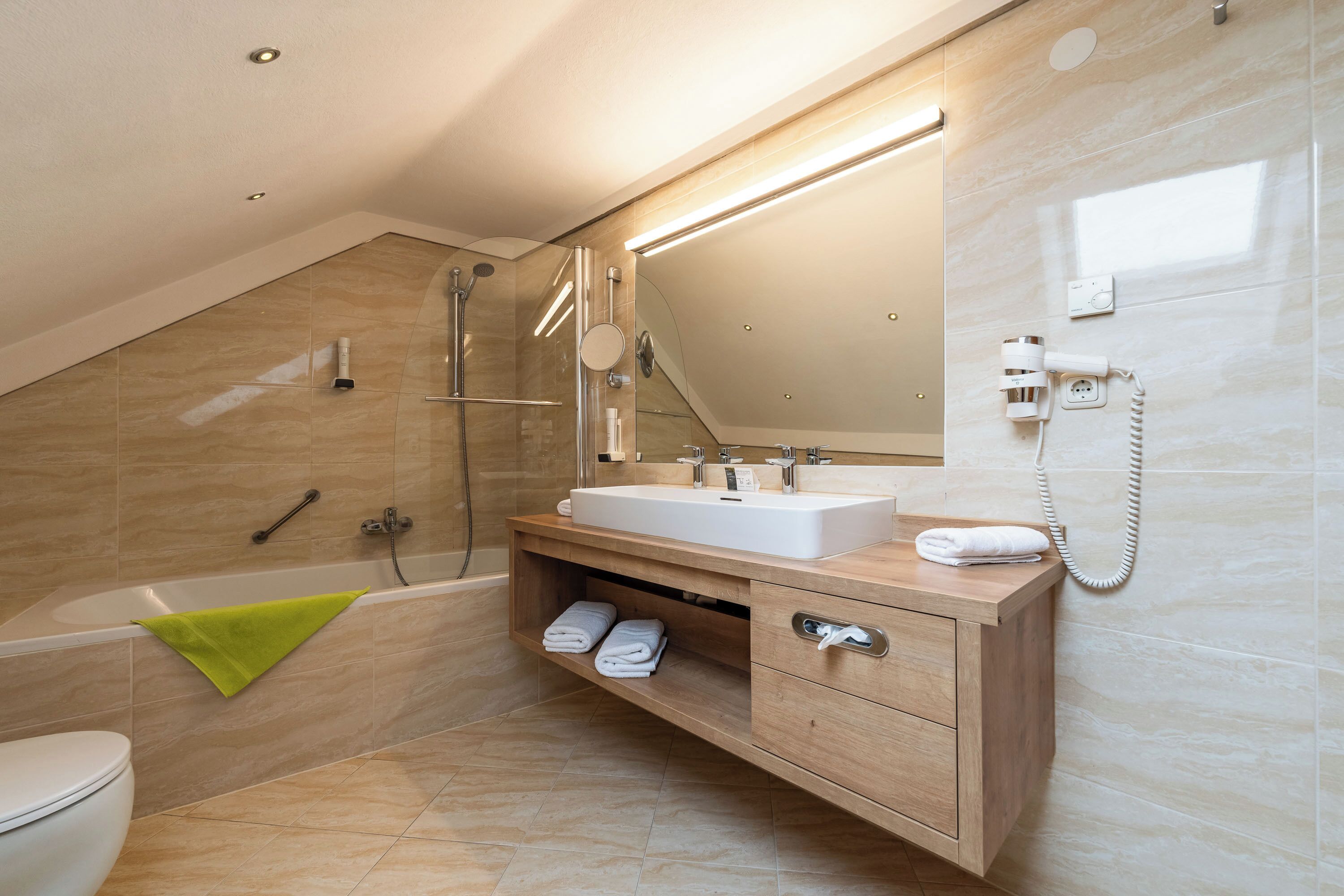 A modern bathroom with a bathtub, a sink, and a vanity.