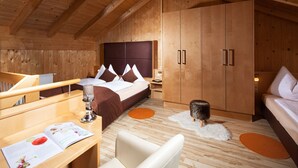 A wooden cabin bedroom with a bed, a desk, and a chair.