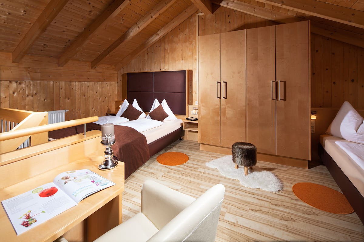 Un dormitorio de cabaña de madera con una cama, un escritorio y una silla.