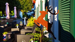 A patio area with wicker furniture and a decorative deer sign on a wall.