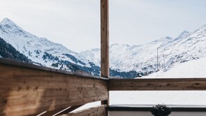 A wooden deck with a view of snow-covered mountains. - The Crystal VAYA Unique (Obergurgl)