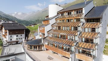 Un hotel de varios pisos con diseño moderno, con balcones y ventanas amplias.